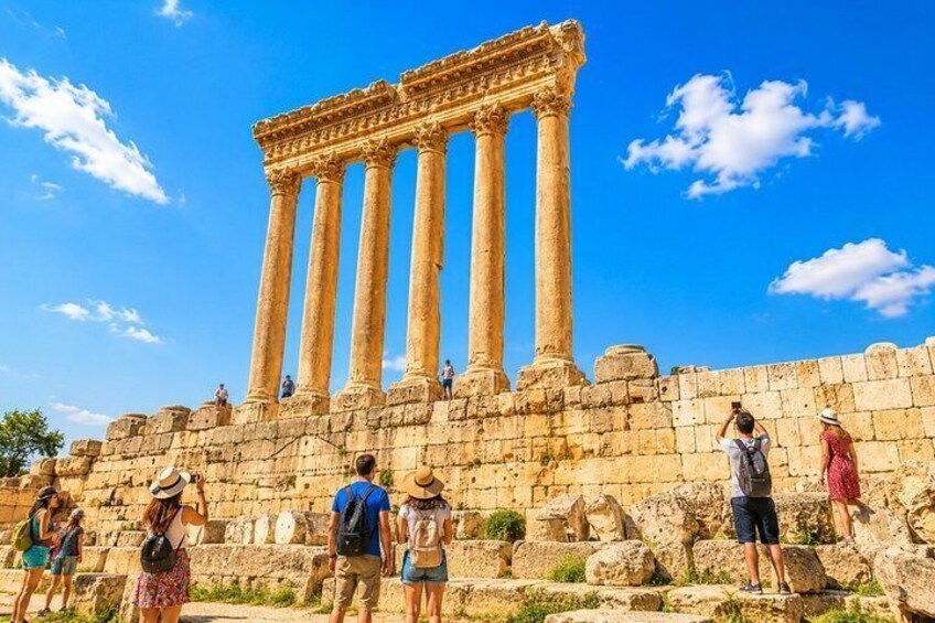 Ancient columns of a historical structure with tourists observing. 1