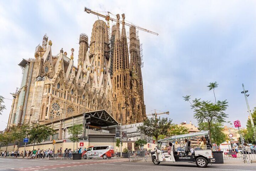 La Sagrada Familia med en byggekran, en bus og en menneskemængde foran. 4