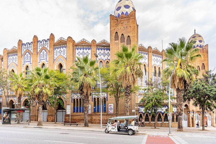 A historic building with intricate tile work, palm trees, and a clear sky. 2