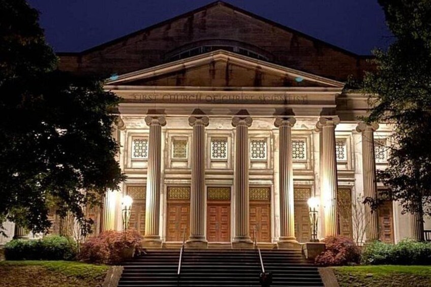 Un edificio clásico con columnas y una entrada imponente de noche. 3