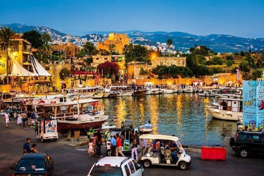 A harbor with boats, a white van, and a red barrier. 1