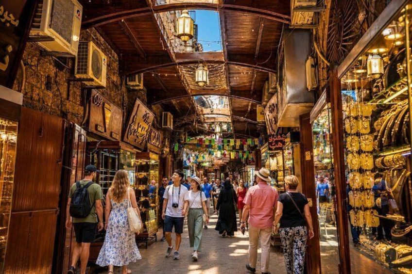 A crowded market with wooden architecture and hanging lanterns. 4