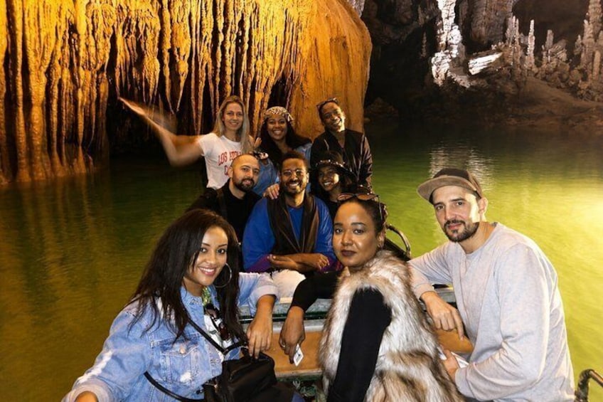 Un grupo de personas en una cueva con estalactitas y un estanque de agua. 3