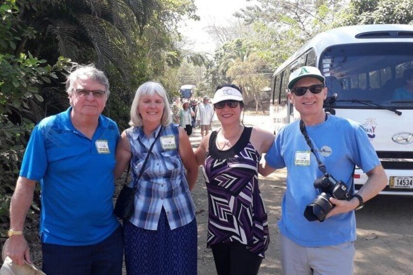 Four people standing on a path with a vehicle in the background. 5