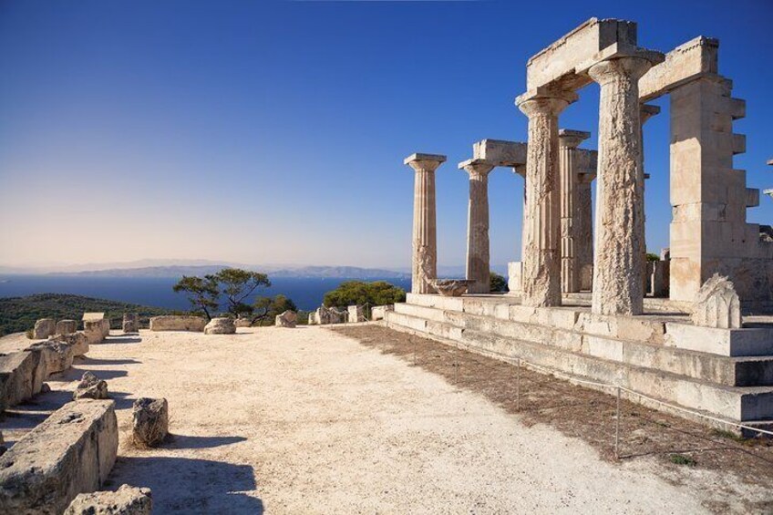 Ancient ruins with columns and a clear view of the sea in the background. 2