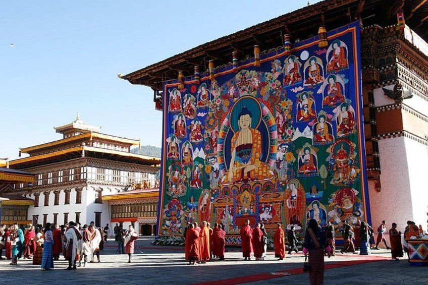 A colorful mural with a central figure, surrounded by various smaller figures and intricate designs, set against a backdrop of traditional architecture. 5
