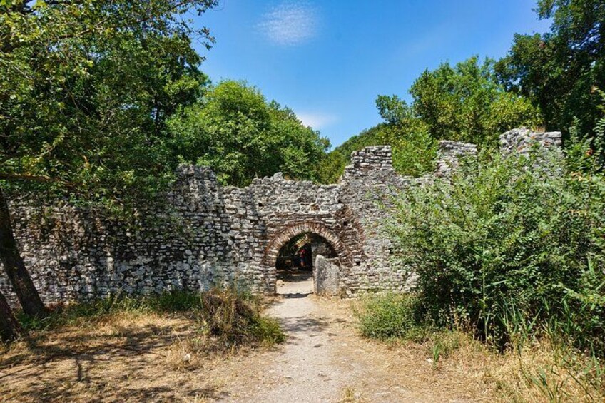 An ancient stone archway surrounded by greenery. 4