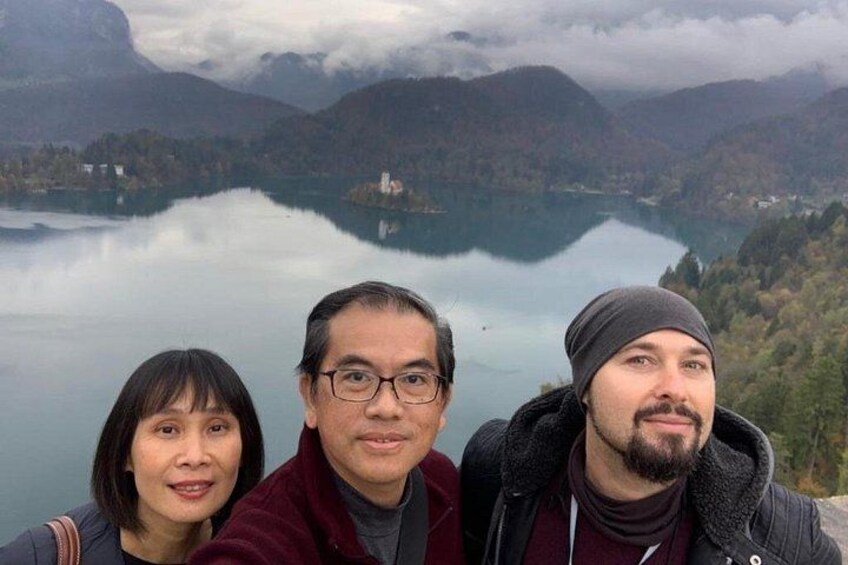 Tres personas junto a un lago, con montañas al fondo. 3