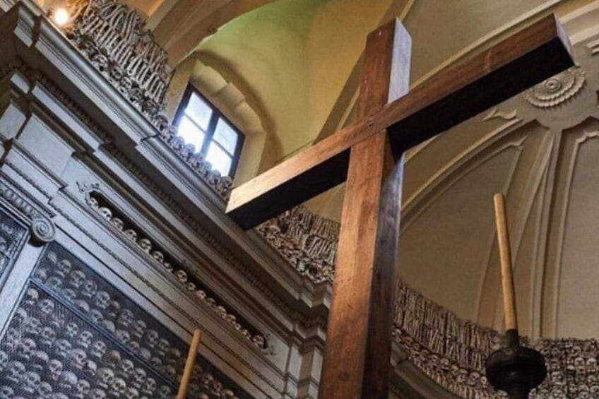 Une croix en bois, des décorations murales richement ornées et un plafond à motifs. 3