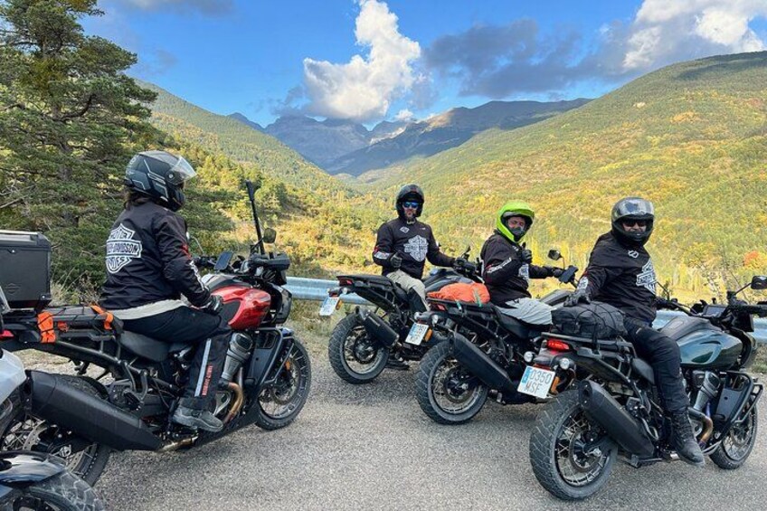 A group of motorcyclists on a road with a mountainous landscape in the background. 5