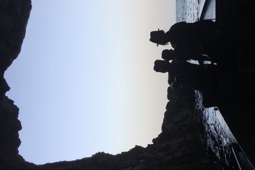 A silhouette of a person climbing a steep rock face. 4