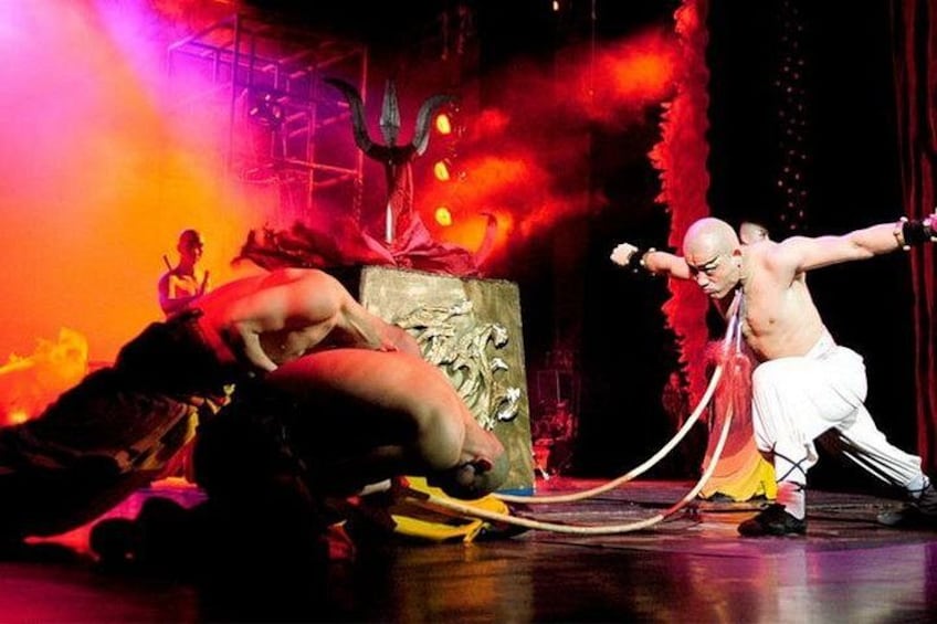 Eine Theatervorstellung mit einer Bühne, einem Dreizack und einem Darsteller in weißen Hosen. 4