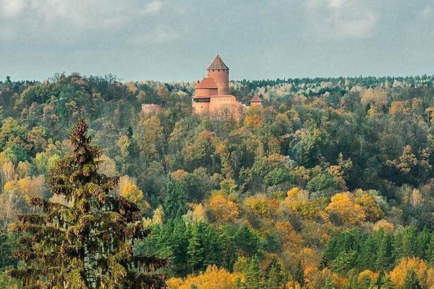 A castle on a hill surrounded by autumn-colored trees. 3