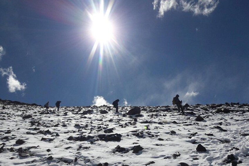 A snowy landscape with the sun shining brightly in the sky. 2