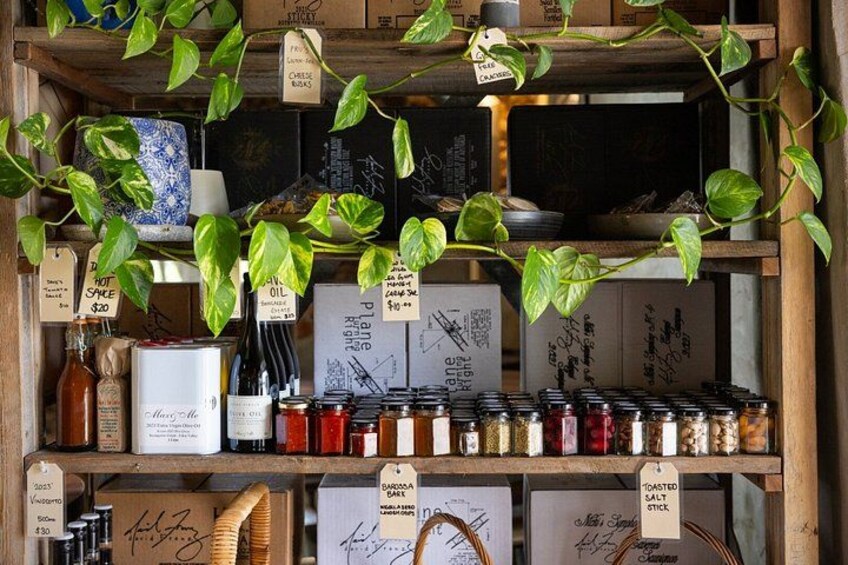 A wooden shelf with jars of spices, a bottle of oil, and a blue and white ceramic pot. 5