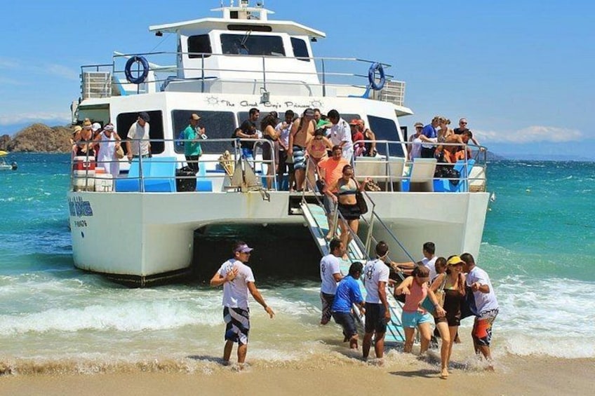 A boat with people boarding and disembarking on a beach. 3