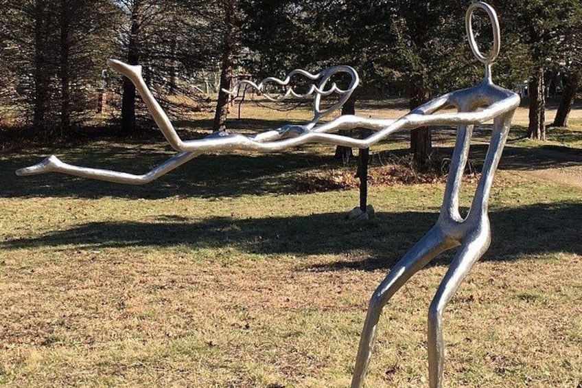 A metal sculpture in a park with trees in the background. 4