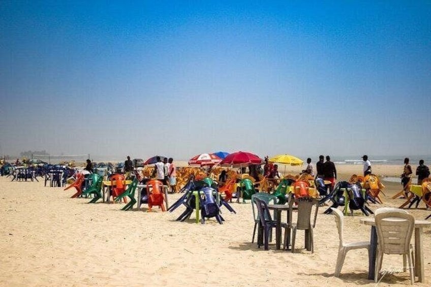 A beach with colorful plastic chairs and umbrellas. 4