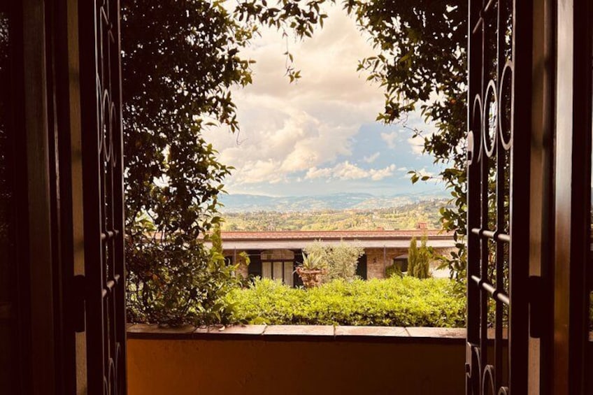 An open gate with a view of a building and a landscape. 1