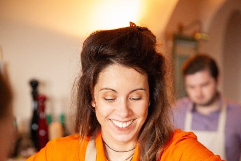 A person in an orange top with a blurred background. 2