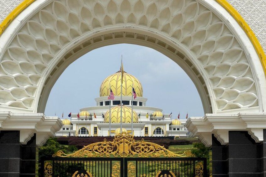 A golden-domed building with a white archway and a black gate. 5