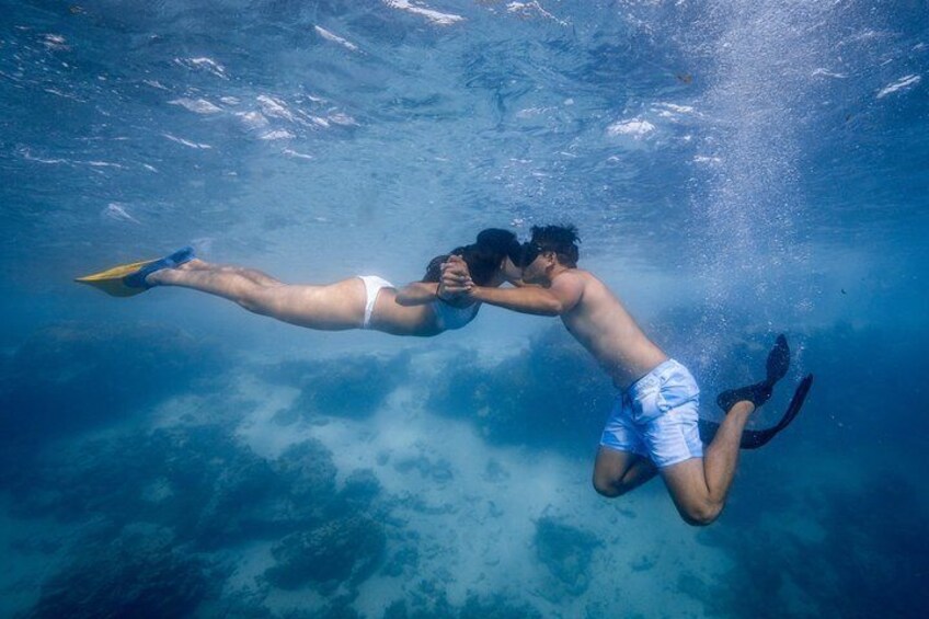Two people swimming underwater. 3