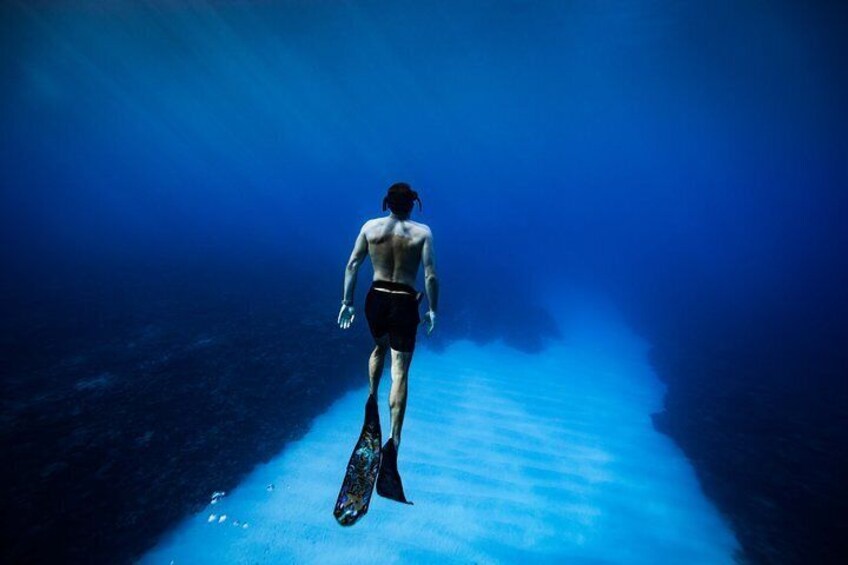 A person walking underwater with fins. 2