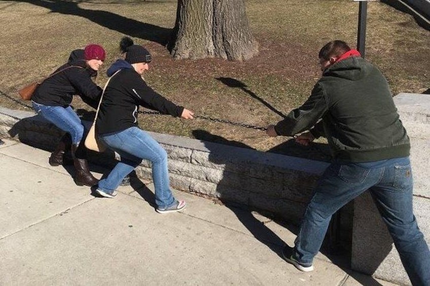 A group of people pushing a chain-link fence. 3
