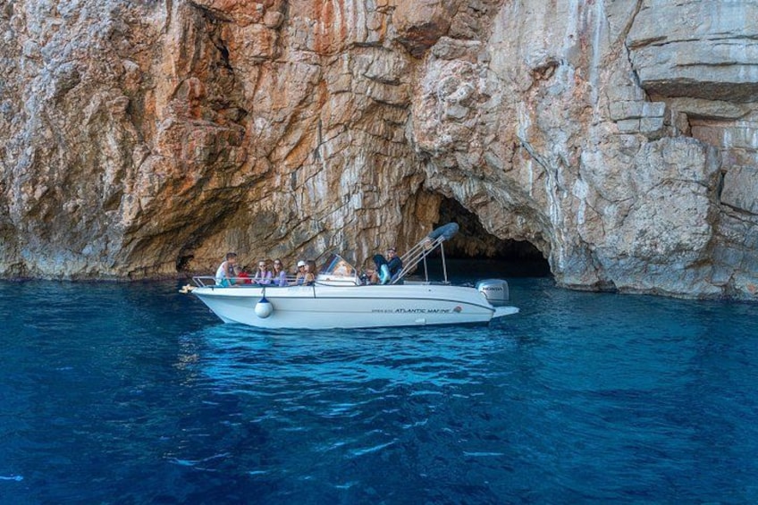 A boat with passengers near a rocky cave entrance. 5