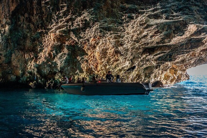 Un barco cerca de una costa rocosa con agua azul cristalina. 1