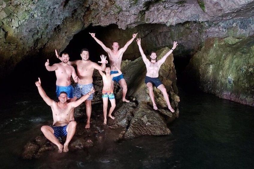 A group of people in a cave with water at the bottom. 4