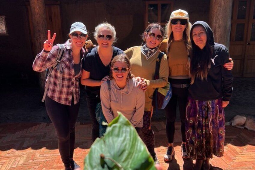A group of people posing in front of a rustic building with a brick floor. 2