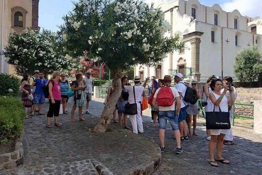 A group of people walking on a cobblestone path with a building in the background. 4