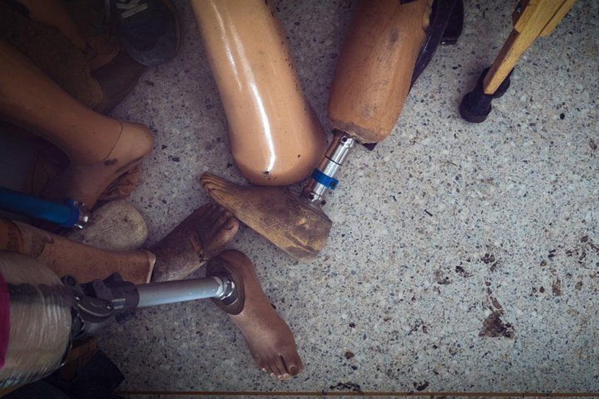 Un par de prótesis de piernas de madera con una articulación metálica y un componente azul. 1
