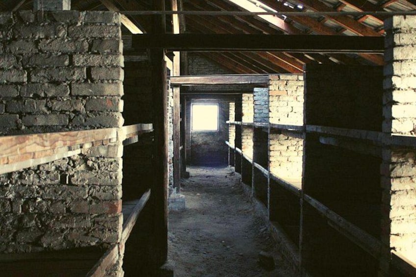 Un interior con paredes de ladrillo, vigas de madera y un pasillo central. 5