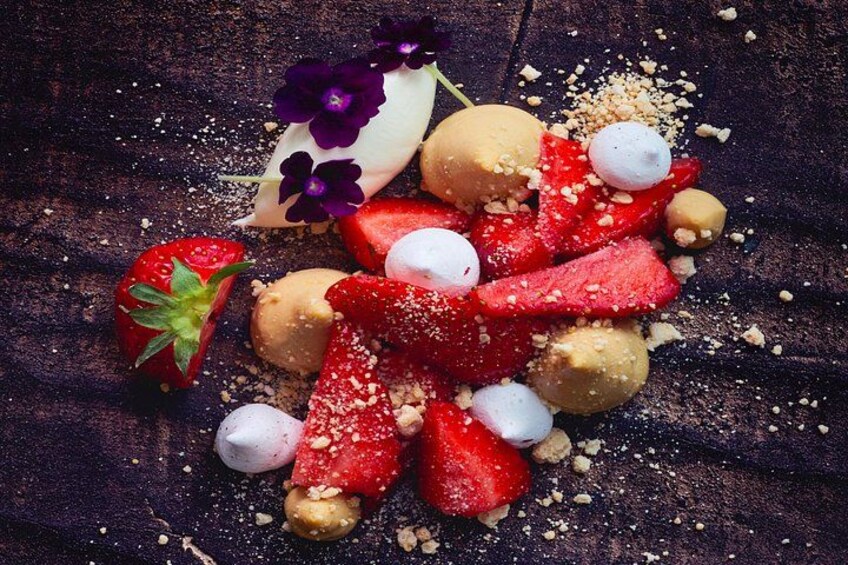 Dessert med jordbær, marshmallows og nødder på en mørk overflade. 4