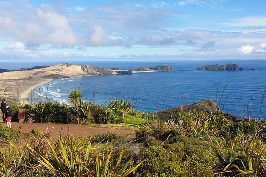 Un paysage côtier avec une plage, l’océan et des îles au loin. 3