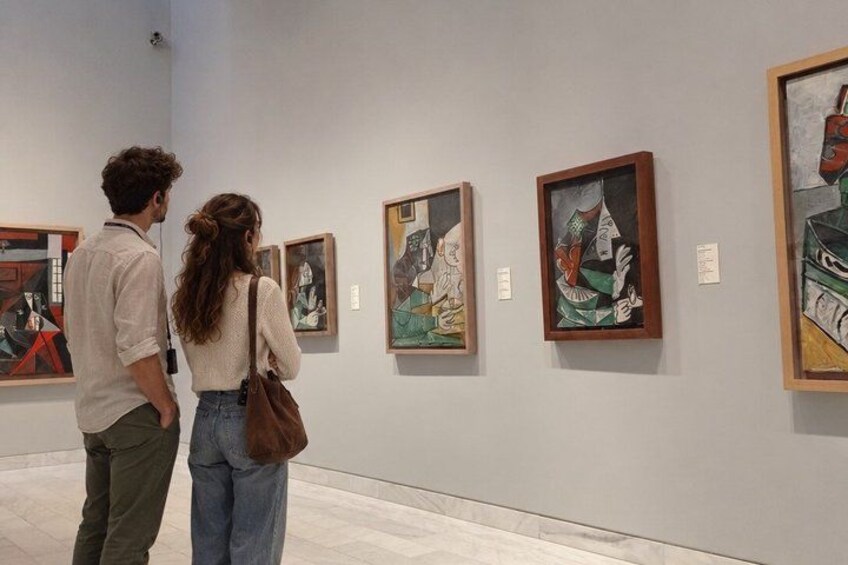 To personer betragter malerier i et galleri. 4