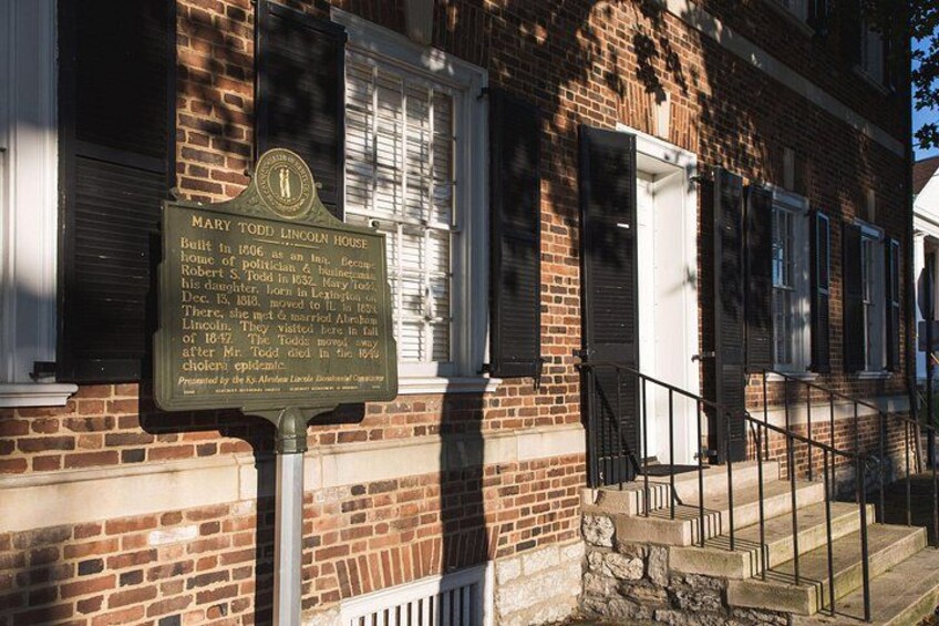 A brick building with a signboard, windows, and a staircase. 2