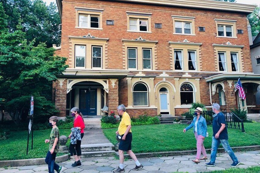 A brick building with a front porch, a flag, and a paved walkway. 4