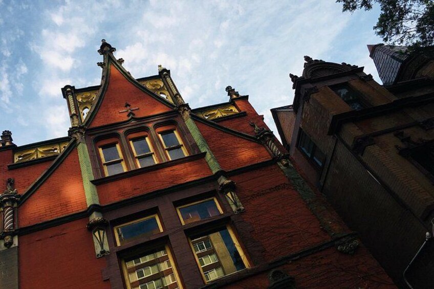 A red brick building with ornate detailing and a steeply pitched roof. 2