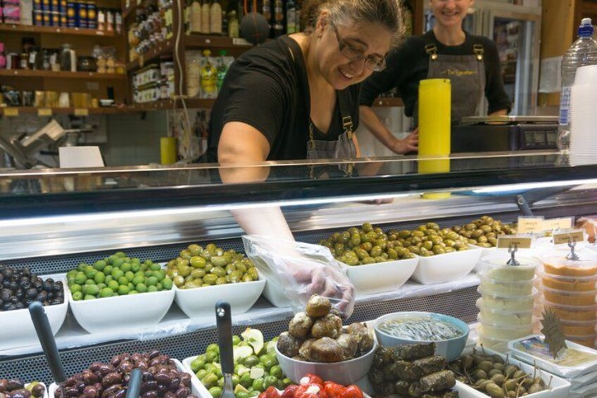 Una barra de charcutería con aceitunas y pepinillos variados expuestos en cuencos. 3