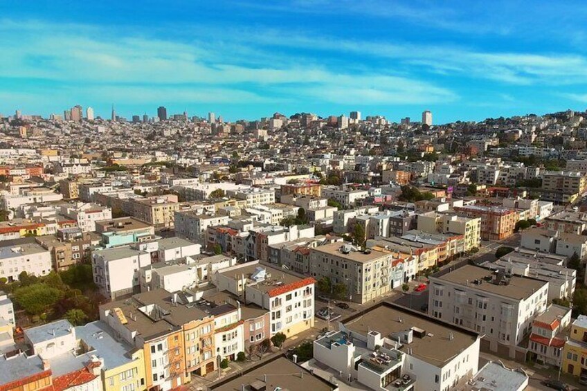 A densely packed urban area with numerous buildings and a distant city skyline. 5