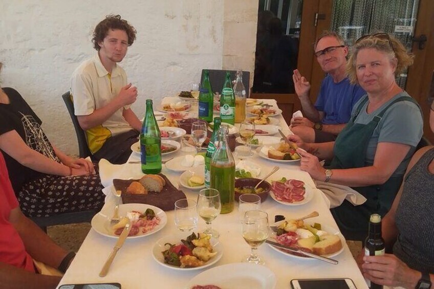 En grupp människor som äter på en restaurang, med olika rätter och drycker på bordet. 3