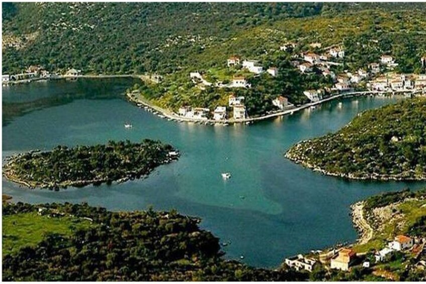 A coastal town with a bay, surrounded by hills and greenery. 1
