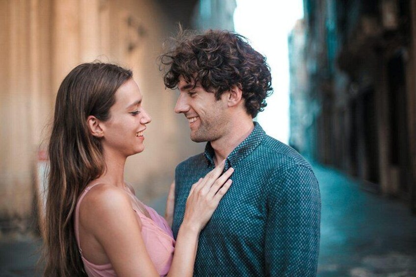 Two people standing close together in an urban alleyway. 2