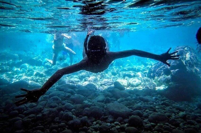 A person swimming underwater with coral formations. 3