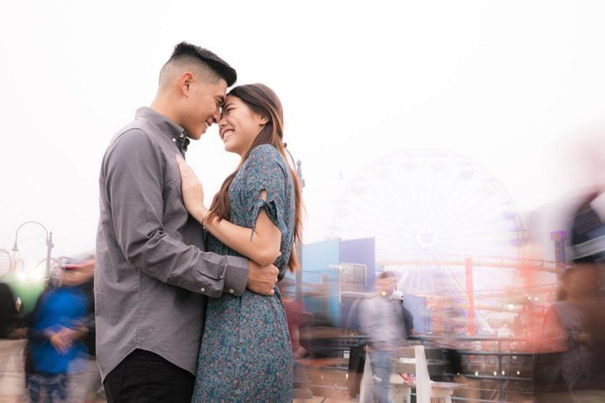 Una pareja abrazándose frente a una noria. 1