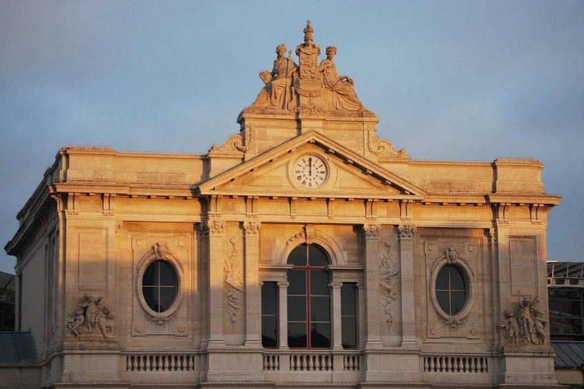 Un edificio clásico con un reloj, esculturas ornamentales y ventanas arqueadas. 5
