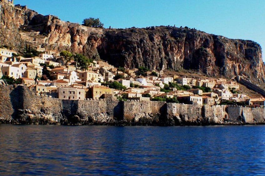 A coastal town built on a cliff, with buildings nestled against the rocky hillside. 1